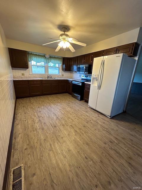 13825 Old Wire Outer Rd, Rolla, MO 65401 - kitchen featuring electric stove, white fridge with ice dispenser, stainless steel microwave, light wood-style flooring, and dark brown cabinetry