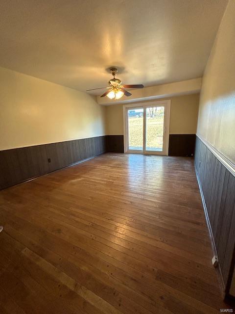 13825 Old Wire Outer Rd, Rolla, MO 65401 - empty room featuring a wainscoted wall, hardwood / wood-style floors, ceiling fan, and wooden walls