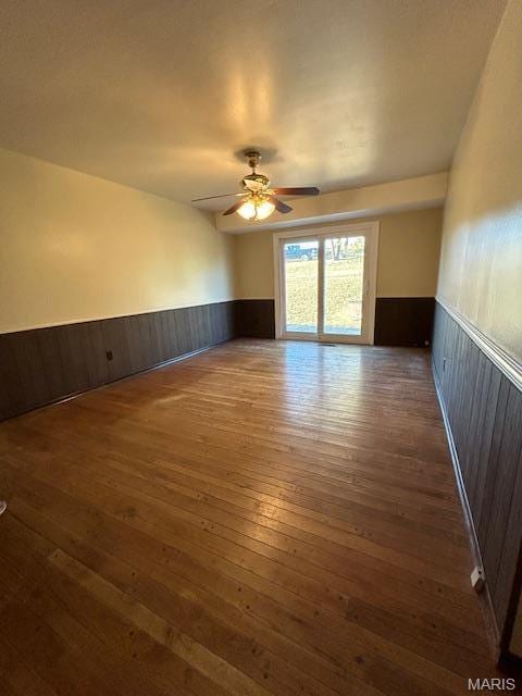 13825 Old Wire Outer Rd, Rolla, MO 65401 - spare room with a wainscoted wall, hardwood / wood-style flooring, a ceiling fan, and wooden walls