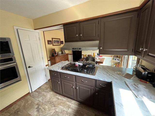 kitchen with appliances with stainless steel finishes, under cabinet range hood, and light stone counters