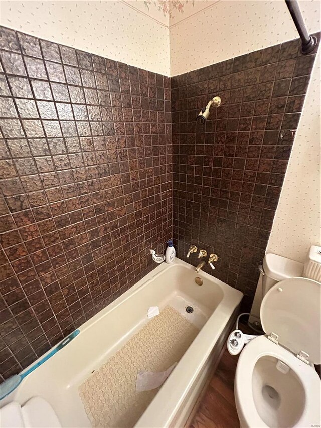 full bathroom featuring bathtub / shower combination, toilet, and wallpapered walls