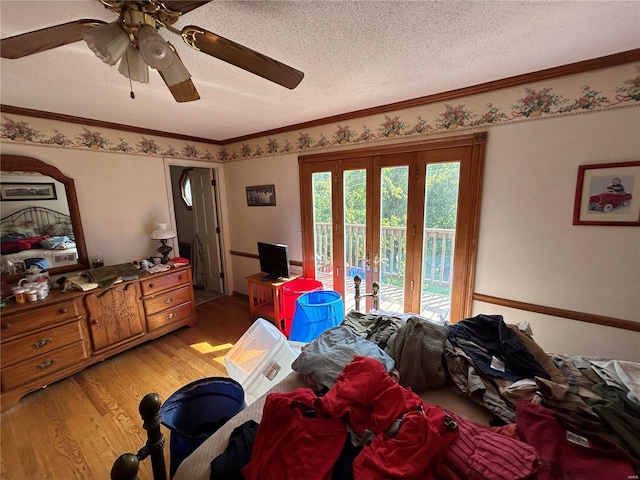 bedroom with access to outside, french doors, light wood-style floors, a textured ceiling, and ornamental molding