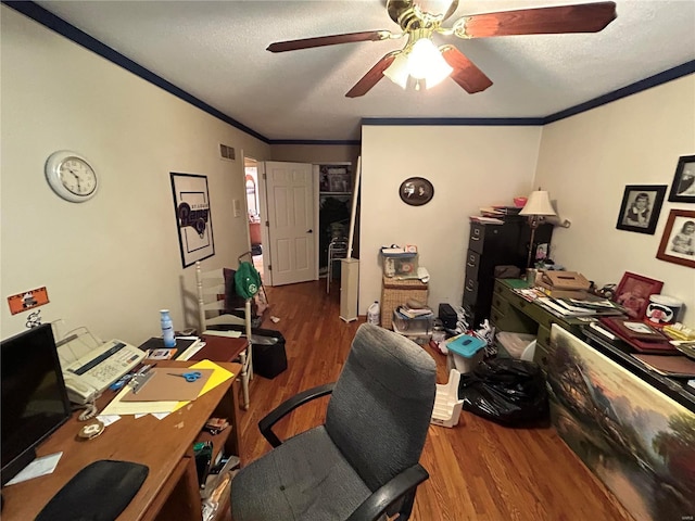 home office featuring a ceiling fan, wood finished floors, ornamental molding, and a textured ceiling