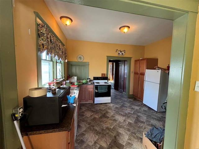 203 W Booneslick Rd, Warrenton, MO 63383 - kitchen featuring white appliances, dark countertops, stone finish flooring, and brown cabinets