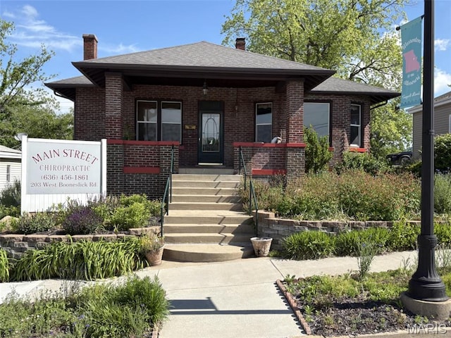 203 W Booneslick Rd, Warrenton, MO 63383 - bungalow featuring brick siding, a chimney, roof with shingles, and covered porch