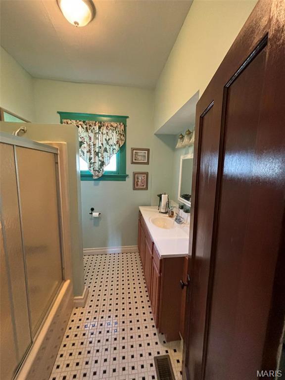 203 W Booneslick Rd, Warrenton, MO 63383 - full bath featuring a shower with door, vanity, tile patterned floors, and baseboards