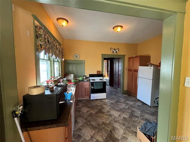 203 W Booneslick Rd, Warrenton, MO 63383 - kitchen with freestanding refrigerator, range with electric cooktop, dark countertops, and stone finish floors