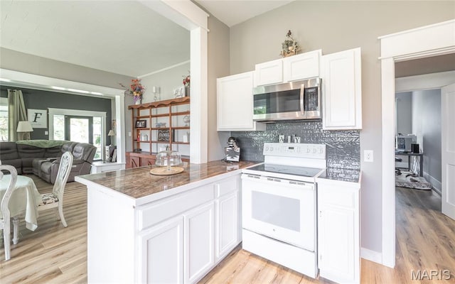 401 W Gibbs, Salem, MO 65560 - kitchen with stainless steel microwave, electric stove, white cabinets, decorative backsplash, and light wood-type flooring
