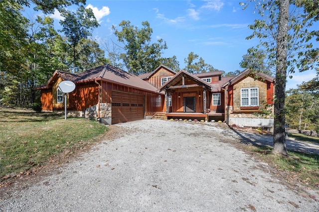 11336 Choctaw Cir, Saint Genevieve, MO 63670 - view of front of house featuring a garage, stone siding, and gravel driveway