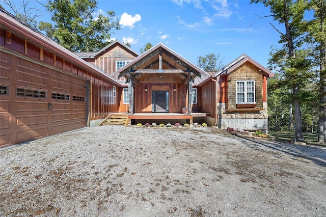 11336 Choctaw Cir, Saint Genevieve, MO 63670 - view of front of home featuring board and batten siding, gravel driveway, covered porch, and an attached garage