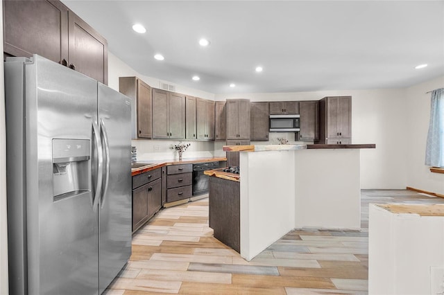 11336 Choctaw Cir, Saint Genevieve, MO 63670 - kitchen featuring appliances with stainless steel finishes, light wood finished floors, dark brown cabinets, recessed lighting, and a center island