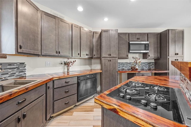 11336 Choctaw Cir, Saint Genevieve, MO 63670 - kitchen featuring butcher block countertops, oven, black gas stovetop, stainless steel microwave, and light wood finished floors