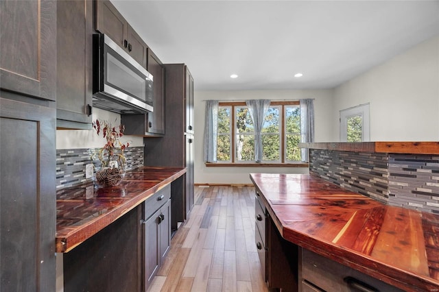 11336 Choctaw Cir, Saint Genevieve, MO 63670 - kitchen with stainless steel microwave, light wood-style flooring, recessed lighting, butcher block counters, and tasteful backsplash