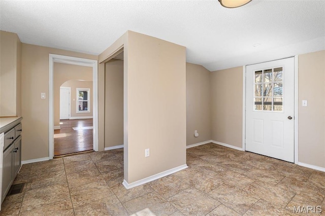 32 Summit St, Bonne Terre, MO 63628 - entryway featuring arched walkways, a textured ceiling, baseboards, and light stone finish flooring