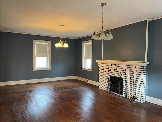 unfurnished living room with a chandelier, plenty of natural light, wood finished floors, and ornamental molding