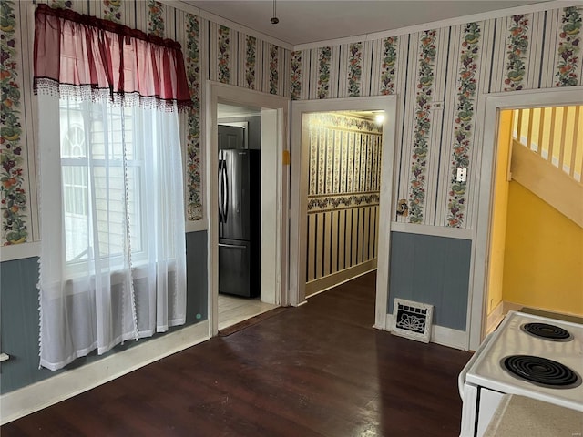 kitchen featuring freestanding refrigerator, white range with electric stovetop, wood finished floors, wallpapered walls, and baseboards