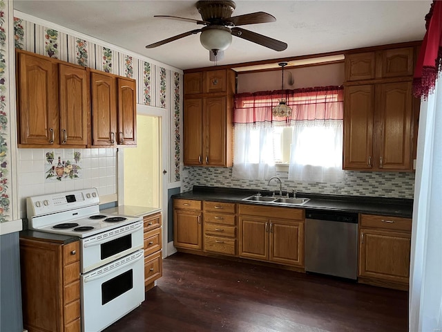 kitchen featuring double oven range, stainless steel dishwasher, a sink, decorative backsplash, and brown cabinetry