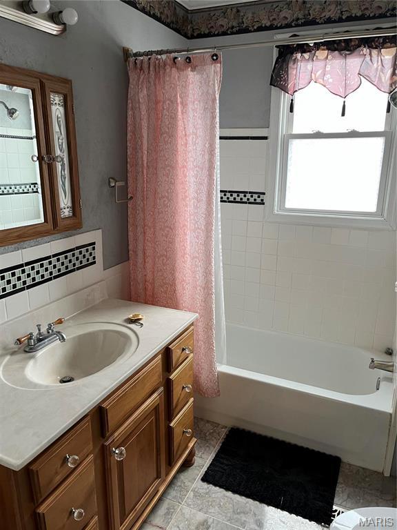 611 W Main St, Staunton, IL 62088 - bathroom with vanity, shower / bath combination with curtain, and decorative backsplash