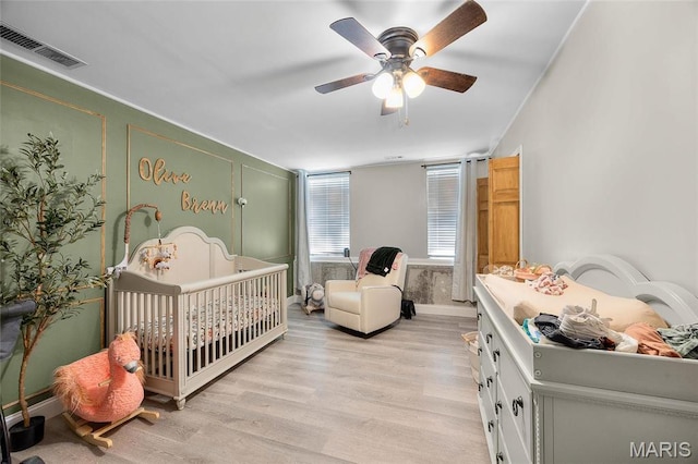 10410 Business 21, Hillsboro, MO 63050 - bedroom with light wood-type flooring, a crib, and ceiling fan