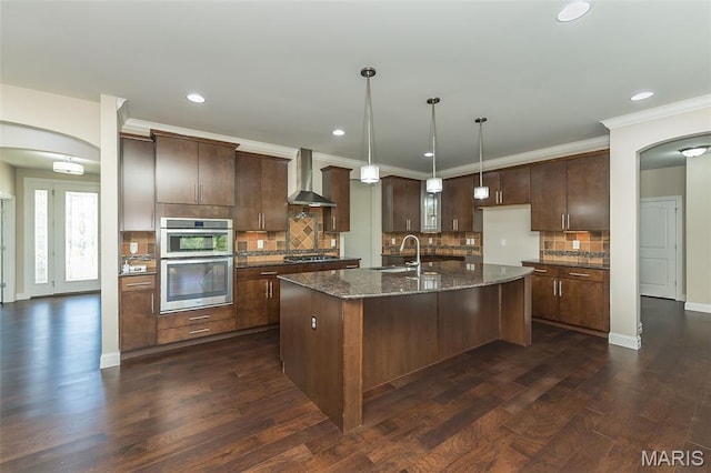 612 Savannah View Way, Chesterfield, MO 63017 - kitchen with wall chimney range hood, a sink, arched walkways, stainless steel double oven, and gas stovetop