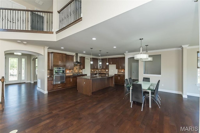 612 Savannah View Way, Chesterfield, MO 63017 - kitchen featuring wall chimney range hood, stainless steel double oven, arched walkways, dark wood-type flooring, and baseboards