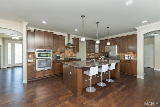 612 Savannah View Way, Chesterfield, MO 63017 - kitchen with stainless steel appliances, wall chimney exhaust hood, a sink, arched walkways, and recessed lighting