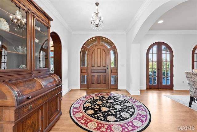 1 Claychester Dr, Saint Louis, MO 63131 - foyer entrance with a chandelier, arched walkways, french doors, light wood finished floors, and ornamental molding