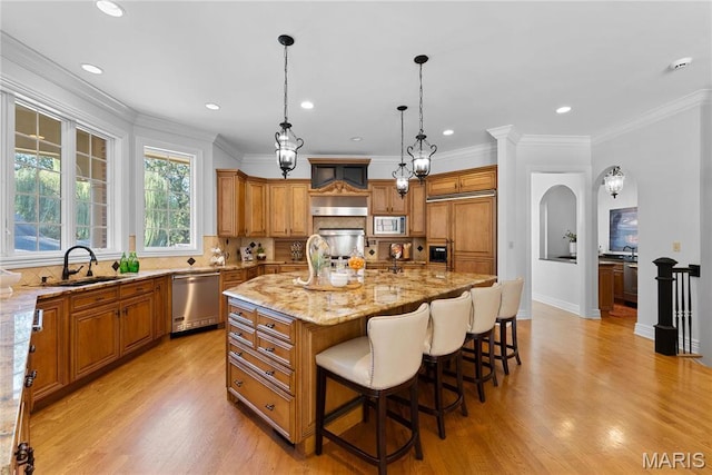 1 Claychester Dr, Saint Louis, MO 63131 - kitchen with appliances with stainless steel finishes, a sink, brown cabinets, light stone countertops, and a breakfast bar area