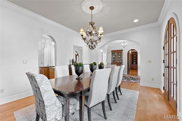 1 Claychester Dr, Saint Louis, MO 63131 - dining room featuring arched walkways, a chandelier, baseboards, light wood finished floors, and crown molding