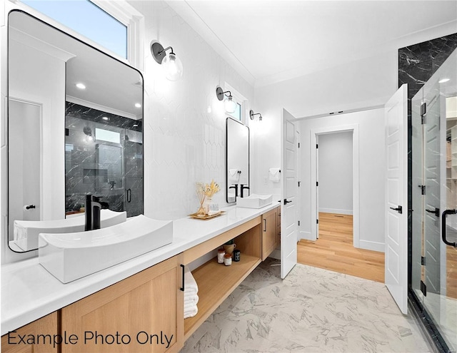full bathroom featuring a shower stall, marble finish flooring, double vanity, crown molding, and recessed lighting