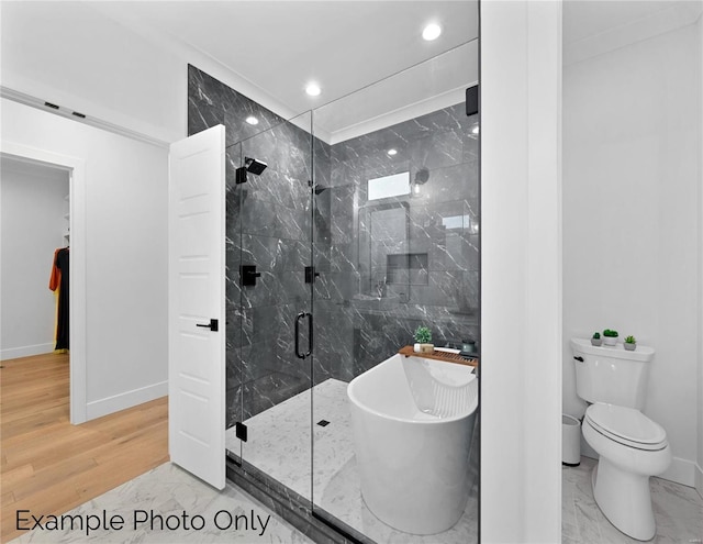 bathroom with a marble finish shower, baseboards, a freestanding bath, wood finished floors, and toilet