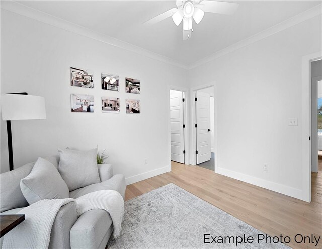 sitting room featuring ceiling fan, light wood-style floors, ornamental molding, and baseboards