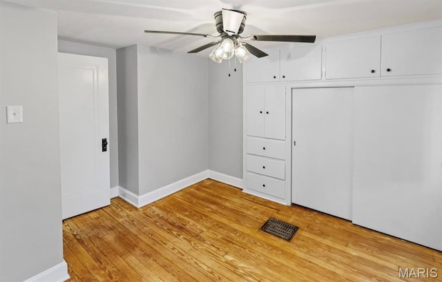unfurnished bedroom with baseboards, light wood finished floors, a closet, and ceiling fan