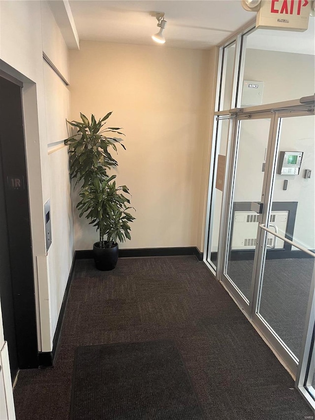 corridor featuring carpet floors and baseboards
