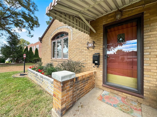 13 N Jackson St, Millstadt, IL 62260 - doorway to property featuring brick siding and a lawn