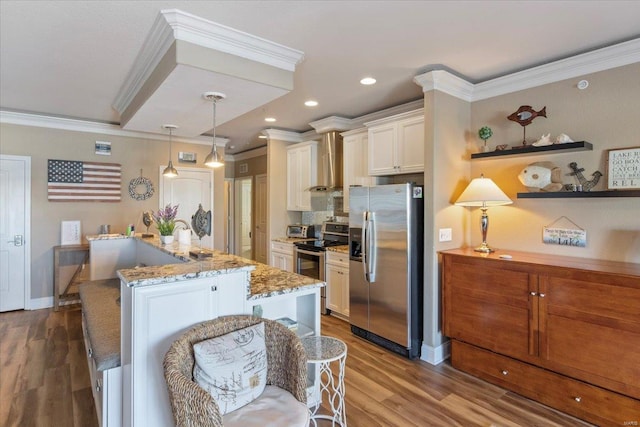 kitchen featuring stainless steel appliances, ornamental molding, wood finished floors, white cabinetry, and a kitchen island with sink