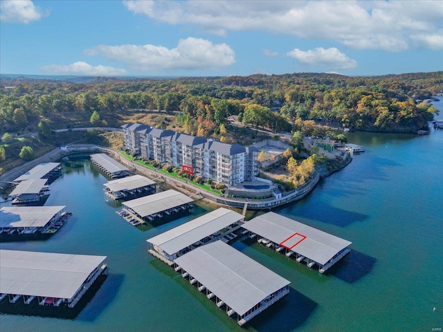 drone / aerial view of a nearby body of water and a forest