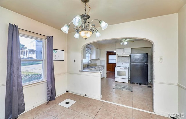 509 Royal Ave, Ferguson, MO 63135 - kitchen with white electric stove, freestanding refrigerator, arched walkways, a sink, and under cabinet range hood