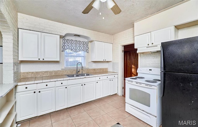 509 Royal Ave, Ferguson, MO 63135 - kitchen with white range with electric cooktop, freestanding refrigerator, a sink, under cabinet range hood, and white cabinetry