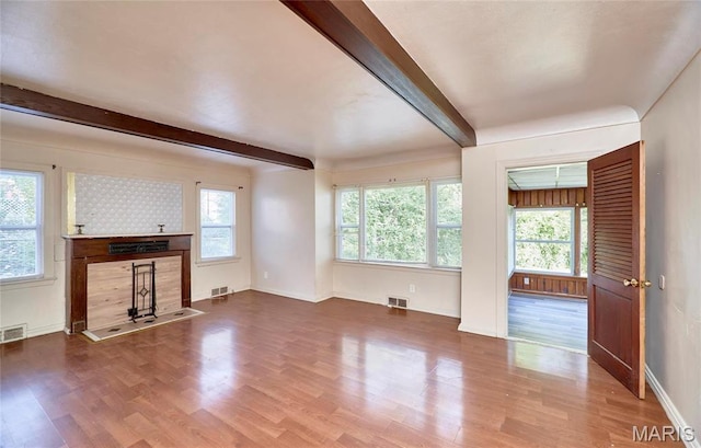 509 Royal Ave, Ferguson, MO 63135 - unfurnished living room with beam ceiling, healthy amount of natural light, wood finished floors, and baseboards