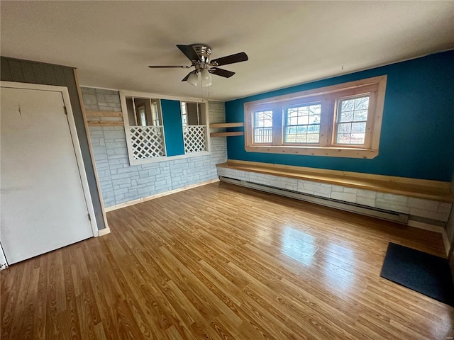 empty room with a baseboard radiator, ceiling fan, and wood finished floors