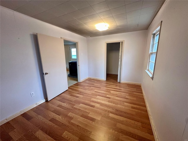 unfurnished room with light wood-type flooring and baseboards