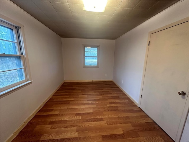 unfurnished room with wood finished floors and baseboards