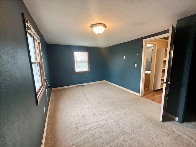 spare room featuring carpet flooring and baseboards