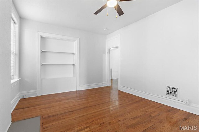3921 Shenandoah Ave, Saint Louis, MO 63110 - unfurnished bedroom with multiple windows, wood finished floors, a closet, and ceiling fan
