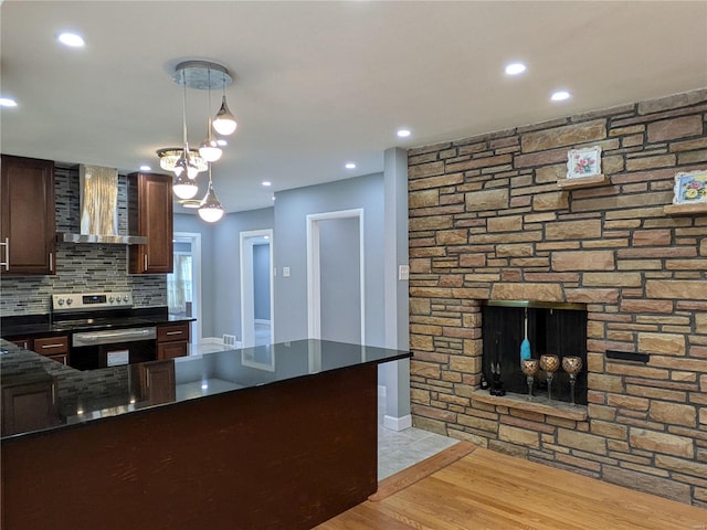 7 Carole Ln, Frontenac, MO 63131 - kitchen with electric range, wall chimney exhaust hood, hanging light fixtures, backsplash, and dark brown cabinets