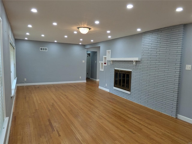 7 Carole Ln, Frontenac, MO 63131 - unfurnished living room featuring a fireplace, recessed lighting, light wood-type flooring, and baseboards