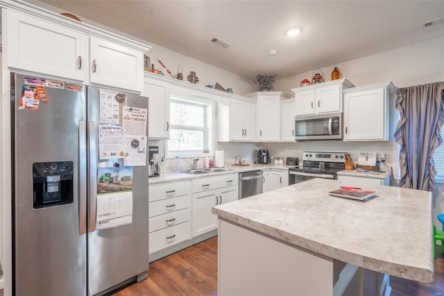 45 Justin Ave, Van Buren, MO 63965 - kitchen featuring stainless steel appliances, a sink, light countertops, white cabinetry, and a kitchen island