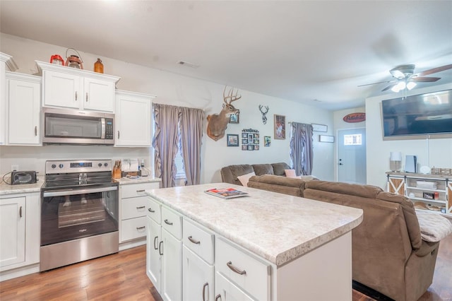 45 Justin Ave, Van Buren, MO 63965 - kitchen with appliances with stainless steel finishes, open floor plan, a ceiling fan, light countertops, and a center island