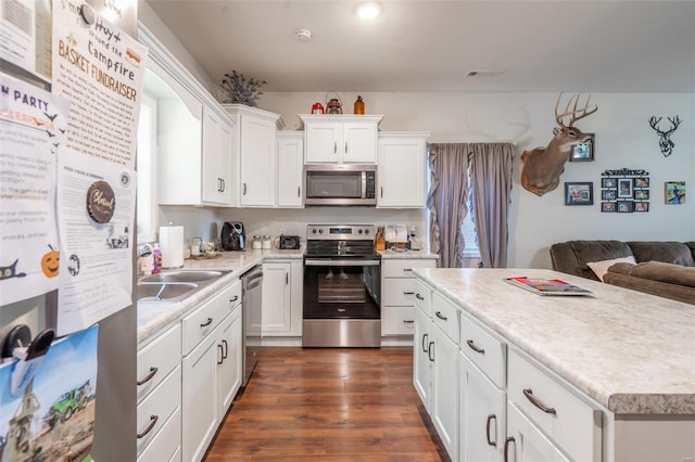 45 Justin Ave, Van Buren, MO 63965 - kitchen with stainless steel appliances, light countertops, white cabinets, and dark wood-style floors